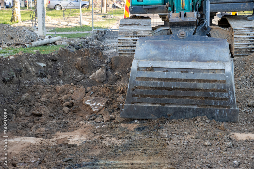 Excavator tearing up the asphalt with the bucket