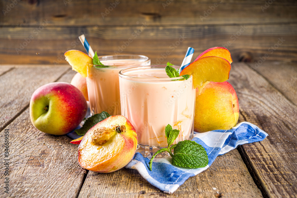 Summer breakfast drink, fresh blended peach smoothie, peach yogurt with nectarine fruit slices, rustic wooden background copy space - obrazy, fototapety, plakaty 