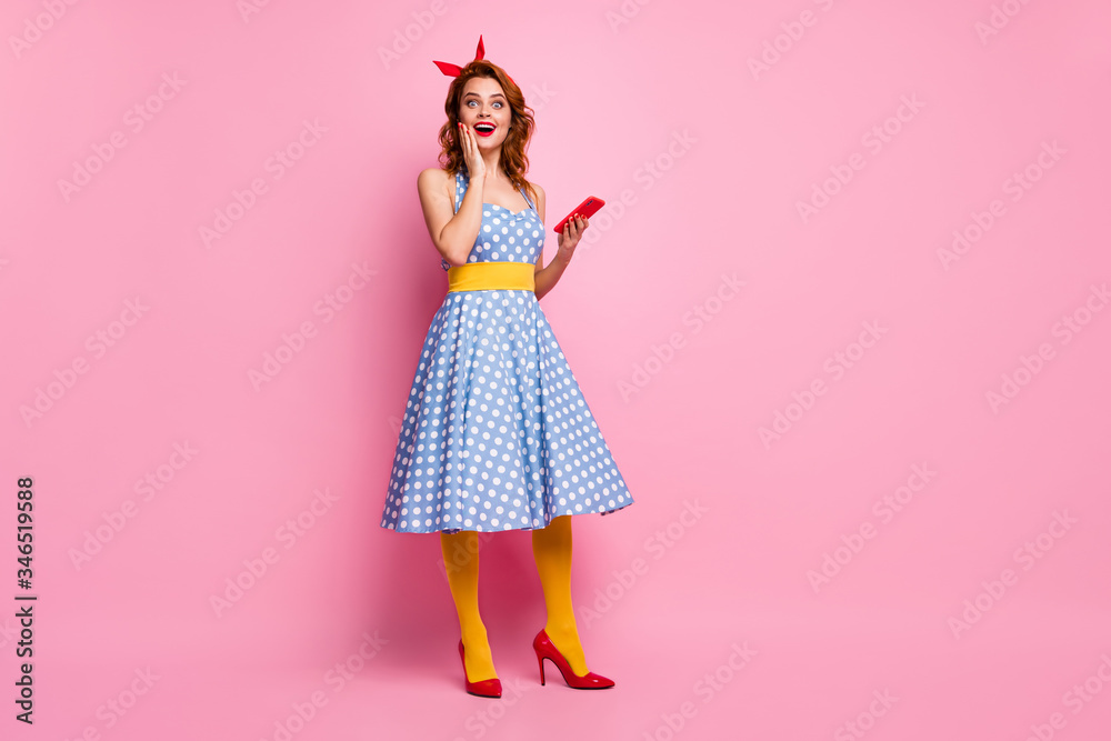 Full body photo of beautiful funny lady hold telephone read good comments blog wear headband dotted dress long skirt red stilettos yellow stockings isolated pink color background Full body photo of beautiful funny lady hold telephone read good comments blog wear headband dotted dress long skirt red stilettos yellow stockings isolated pink color background