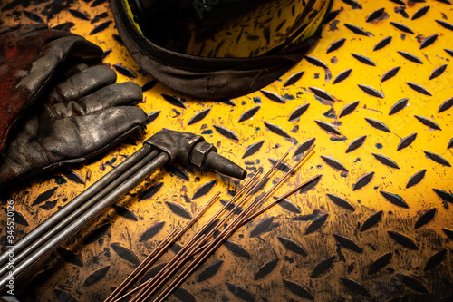 Gas welding and safety equipment on a grunge yellow checkerplate background surface photo