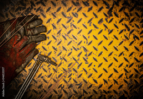 Gas welding and safety equipment on a grunge yellow checkerplate background surface