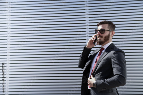 Businessman wears mask to prevent coronavirus. Excellent photo to express the concept of responsibility.  Modern architecture on the background © filippo