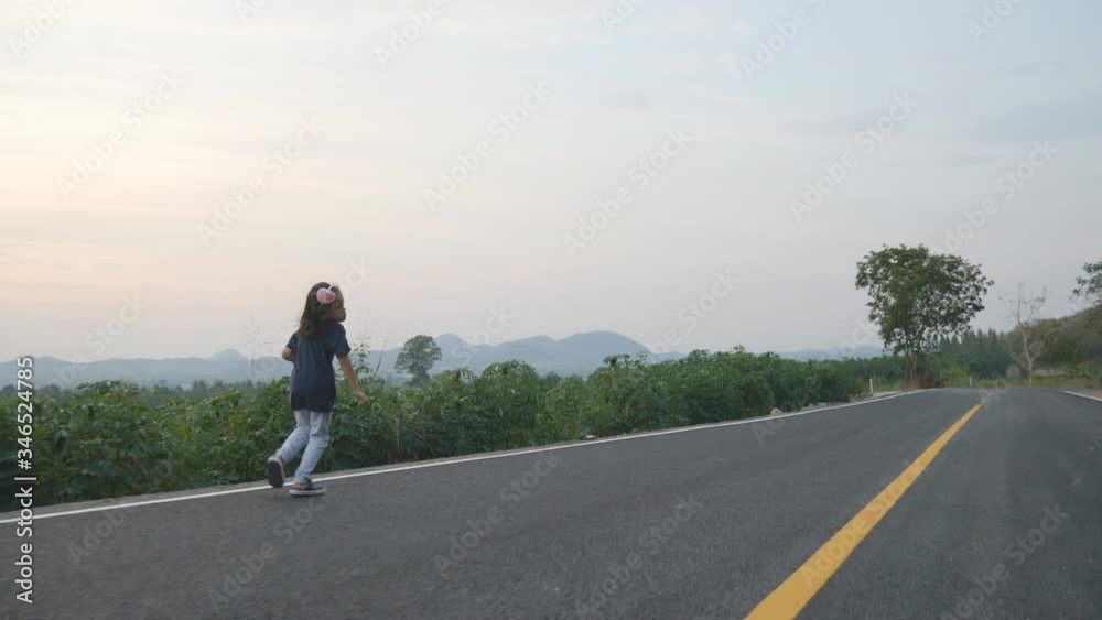 The Asian children relaxing walking on the street road The Asian children relaxing walking on the street road