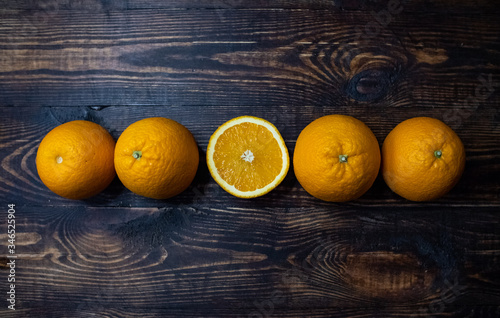 Oranges lie on a wooden surface. Wooden background. Grunge texture background. Poster design. Nature background. Sweet fruit. Design element. Concept of product design. Tropical fruit