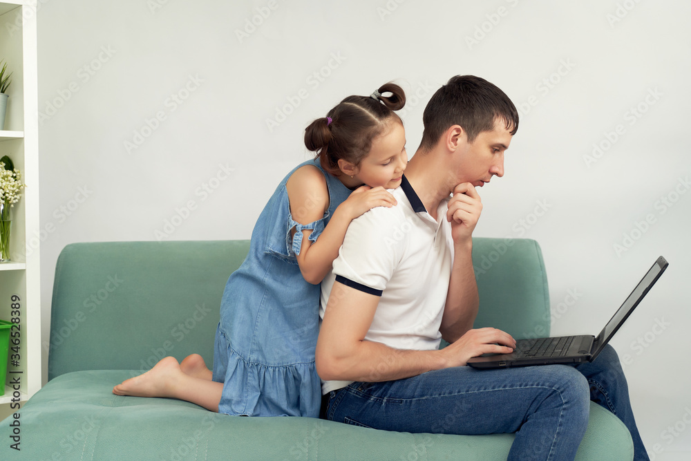 Freelancer working at home in comfortable conditions. Man trying to work, child prevents his father to work. Freelancer working at home in comfortable conditions. Man trying to work, child prevents his father to work.