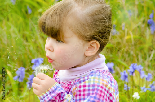 attractive girl blowing on a dandelion to make a wish © Image'in