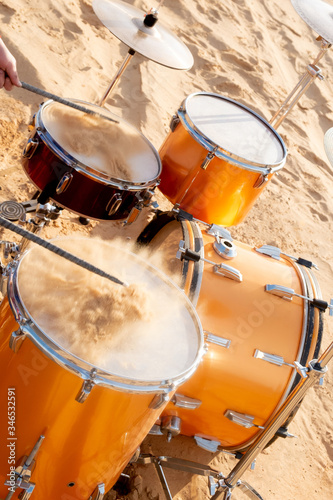 musician plays the drums. The drums are filled with sand. From the impact, the sand crumbles up and to the sides. Concept - drive, aggression and peppy rock music