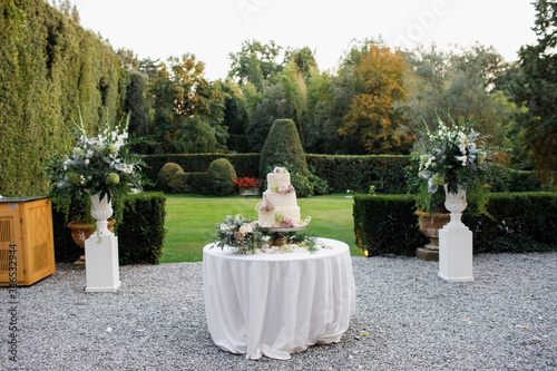 Wedding cake outside. Lots of flowers.