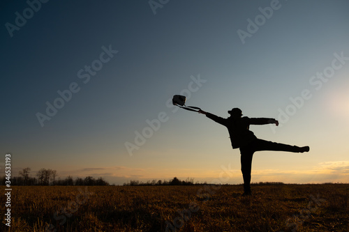 The contour of a man against the sky. A man throws a bag out of his hand in a pose of separation. Problem Solving Concept