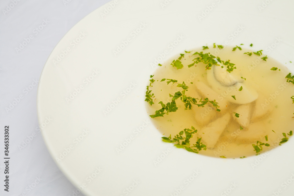 Soup with egg and meat, on a large white plate, white background Soup with egg and meat, on a large white plate, white background