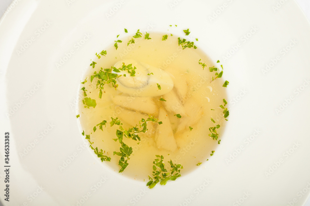 Soup with egg and meat, on a large white plate, white background Soup with egg and meat, on a large white plate, white background