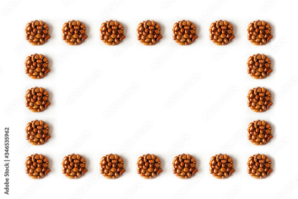 Creative frame arrangement made with teasty eastern sweets kozinaki made from peanuts and honey on a white background. Creative frame arrangement made with teasty eastern sweets kozinaki made from peanuts and honey on a white background.