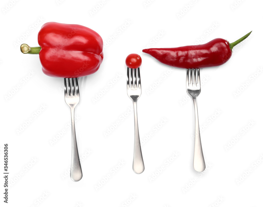 A healthy diet food from vegetables on forks. different type of peppers and cherry tomato isolated on white background