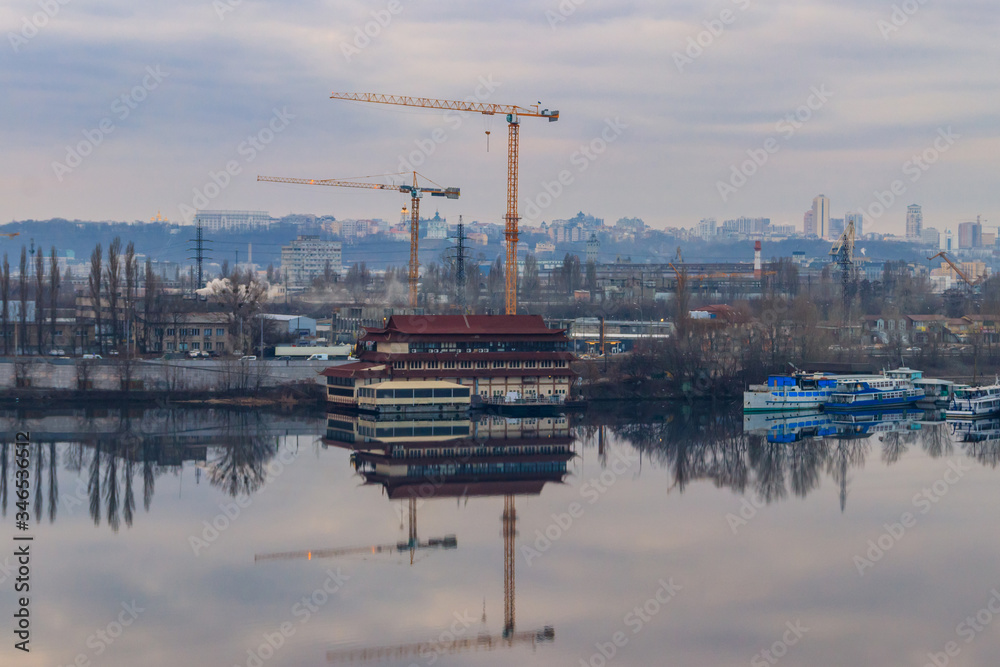 View of the Dnieper river and construction cranes on right bank in Kiev, Ukraine