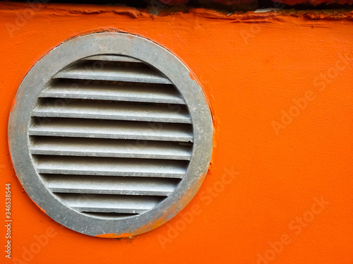 Wallpaper Mural Round new metal ventilation grill on the wall of a building. Background of an orange building. Place for text. Torontodigital.ca