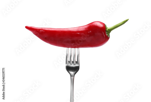 side view of red pepper on fork on white background. Domestic cultivation. Fresh vegetables. Vegetarian dinner. Paprika on a fork. Isolated from background © Andriy Medvediuk