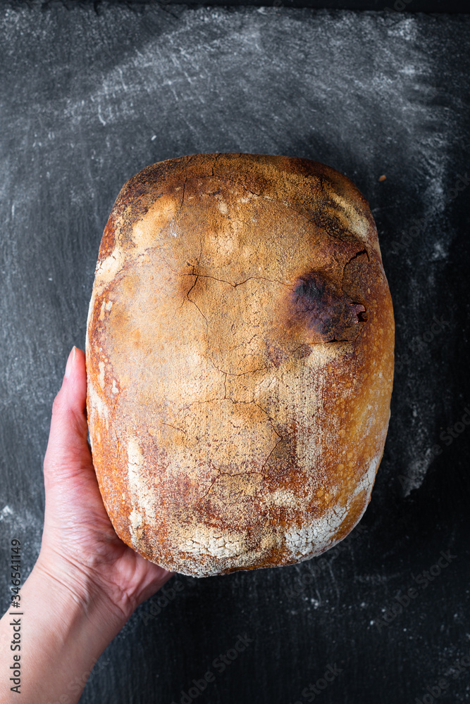 Dark mood and tone Home Cooking Homemade Organic rustic Sourdough bread on black background with copy space Dark mood and tone Home Cooking Homemade Organic rustic Sourdough bread on black background with copy space