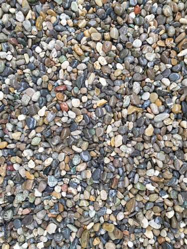 Colored, rounded and wet pebbles as a background.
