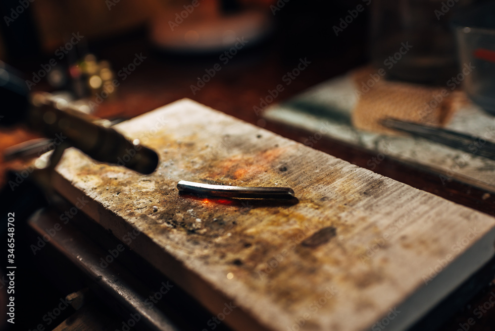 The fire from the torch heats a bar of pure silver ore. The fire from the torch heats a bar of pure silver ore.