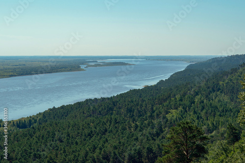 a beautiful view of the river, fields and coniferous forest opens from above