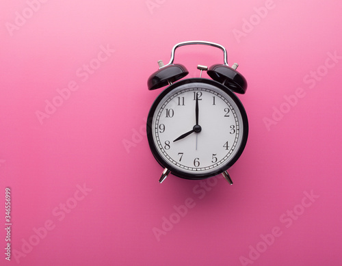 Retro Alarm Clock on Pink Background with Copy Space Isolated Pointing Eight O Clock