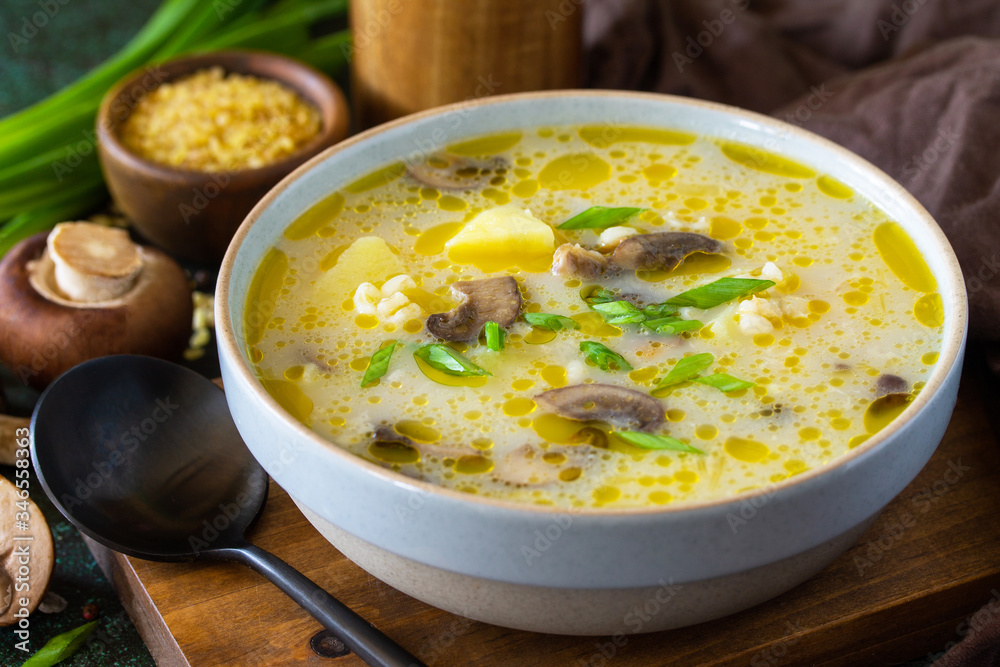 Diet and healthy eating concept. Royal Mushroom cream soup with bulgur on a dark stone background.