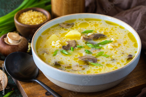 Diet and healthy eating concept. Royal Mushroom cream soup with bulgur on a dark stone background.