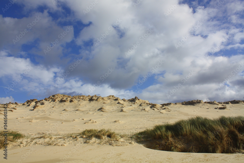 Blick vom Strand auf eine Sanddüne mit blauen Himmel und Wolken. Atlantischer Ozean. Biscarrosse. Frankreich