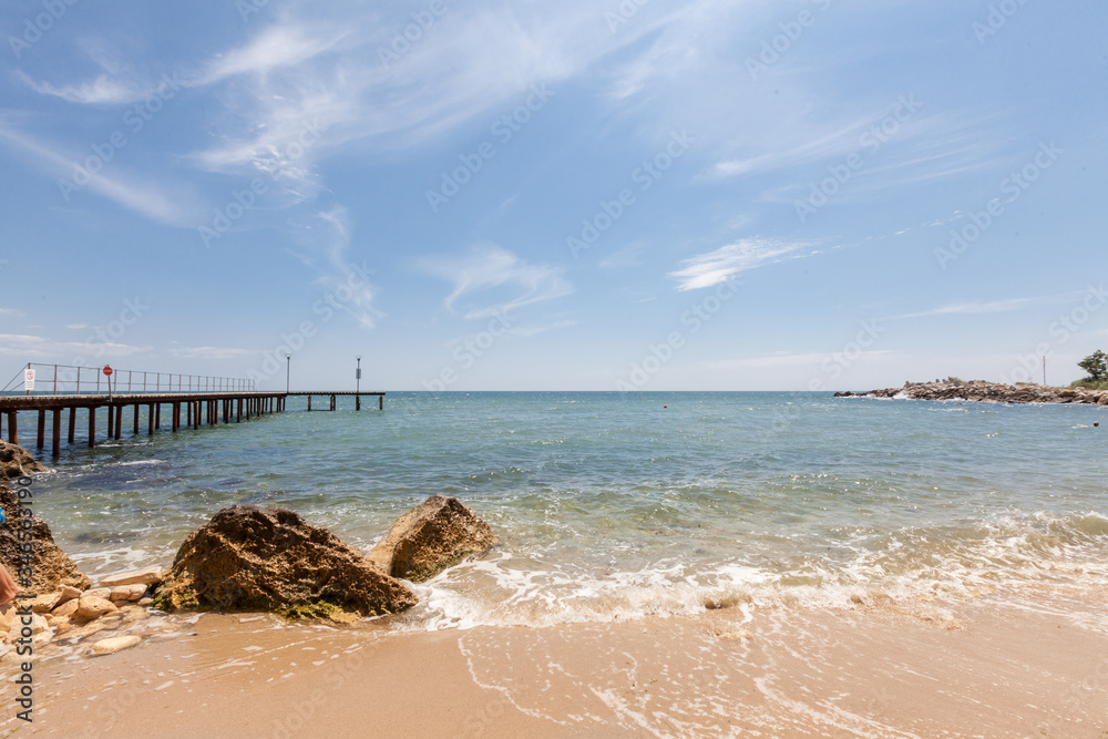 Beach with rocks and blue sky. Summer vacation background