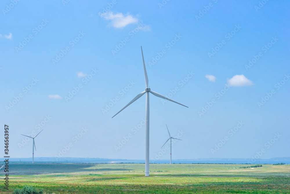 three wind generators on the field on a sunny day three wind generators on the field on a sunny day