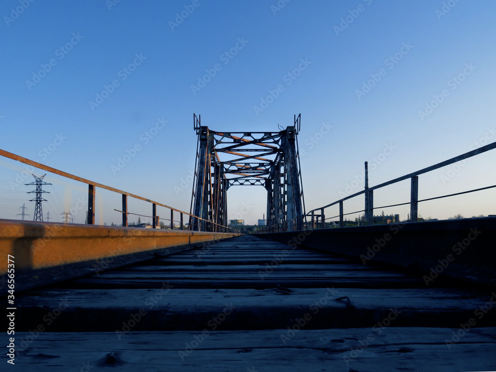 Fototapeta premium Old railway bridge at dawn. Photo in blue tones.