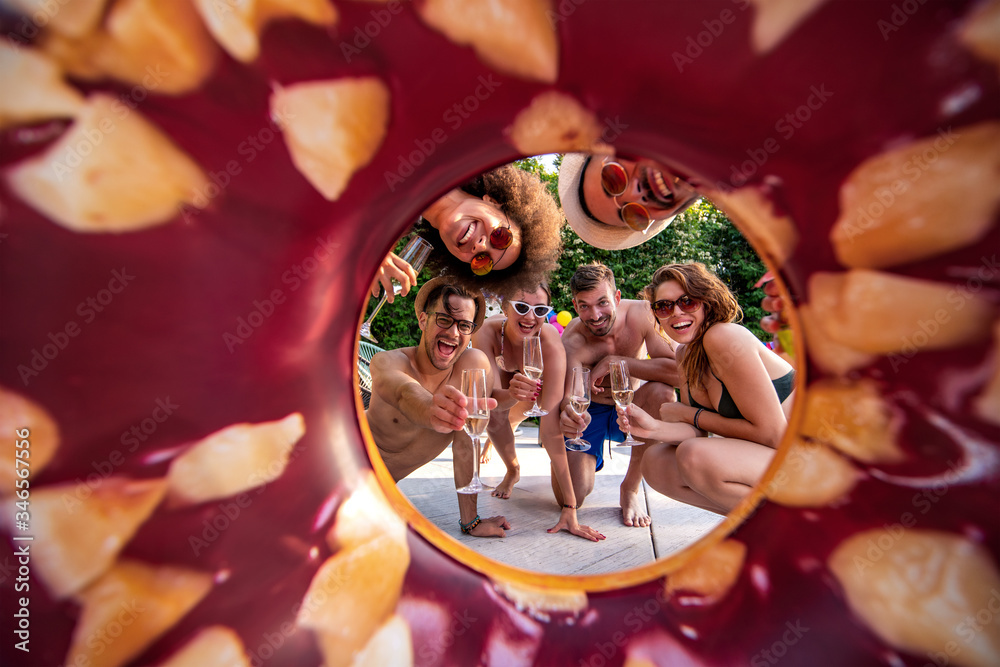 Group of friends having party by swimming pool