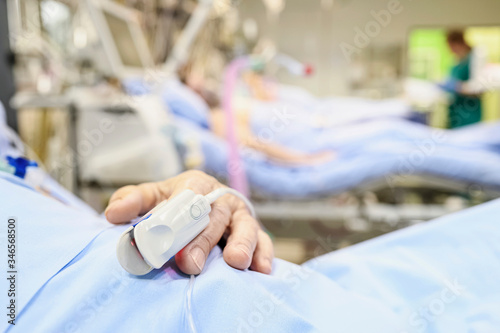 Blood oxymetry probe on a patient hand in intensive care unit. photo