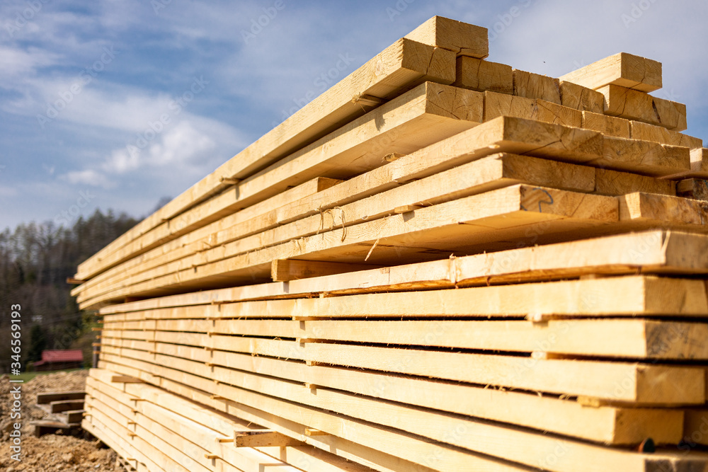 Stack of wooden beams on construction site prepared for building a house Stack of wooden beams on construction site prepared for building a house