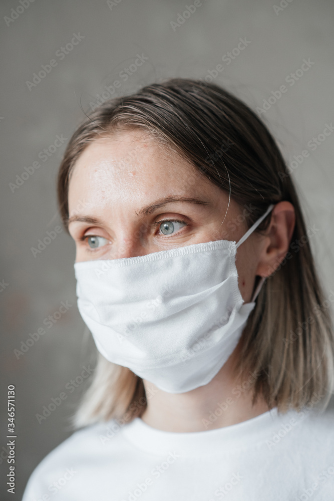 .young girl with short hair in a white t-shirt in a mask, at home, close-up. Coronavirus. Quarantine .young girl with short hair in a white t-shirt in a mask, at home, close-up. Coronavirus. Quarantine