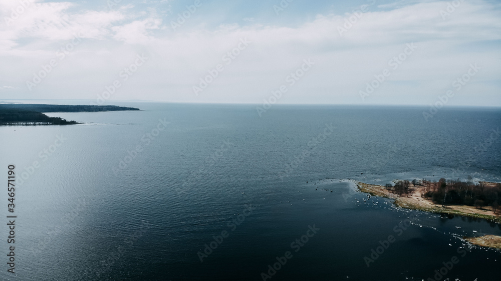 Ocean shore view from quadcopter, sand and rocks on the sea coast. Ocean shore top view. Horizon and blue water. Ocean shore view from quadcopter, sand and rocks on the sea coast. Ocean shore top view. Horizon and blue water.