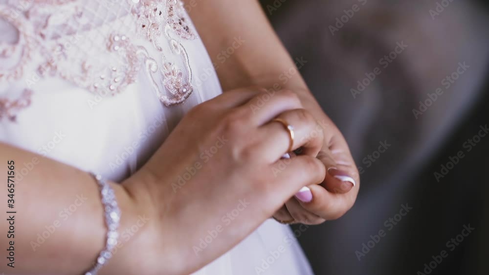 CU shot, slow motion: young bride wearing elegant white wedding dress with gentle laces and shiny bracelet on wrist shows engagement ring closeup CU shot, slow motion: young bride wearing elegant white wedding dress with gentle laces and shiny bracelet on wrist shows engagement ring closeup