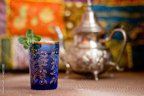 Moroccan tea in a blue glass and a teapot