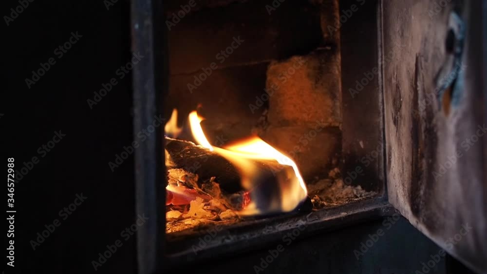 Wood burning in a castiron stove, closeup. Heating a country house