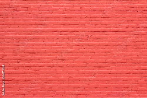 Old red painted brick wall texture background showing weathering from normal aging