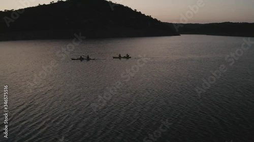 Double canoes sailing through reservoir at sunset photo