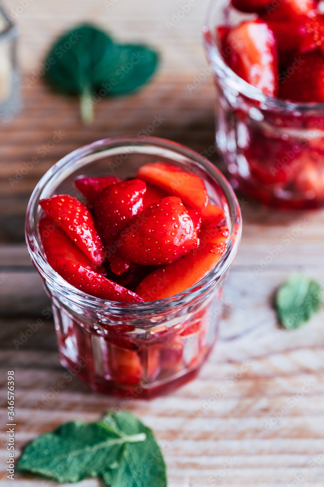 Salade de fruits frais - Fraises au sucre et à la menthe dans un pot en verre