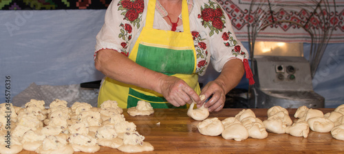 Traditional east european woman in authentic clothing kneading bread dough for 