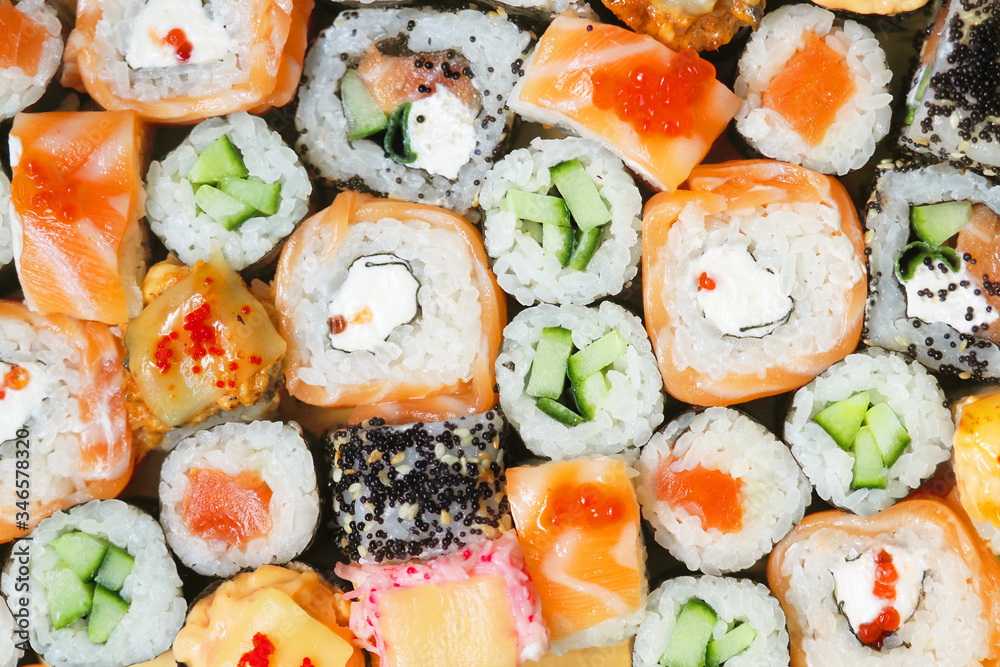 Japanese sushi food background. Maki ands rolls with tuna, salmon, shrimp, crab and avocado. Top view of assorted sushi roll Japanese sushi food background. Maki ands rolls with tuna, salmon, shrimp, crab and avocado. Top view of assorted sushi roll