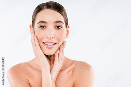 Attractive naked woman with perfect skin posing in studio, looking at camera isolated on white background