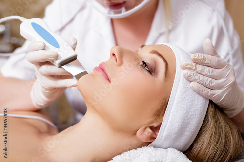 cosmetology and beauty concept - beautiful woman receiving ultrasound cavitation facial peeling photo