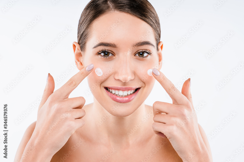 Attractive young woman applying cream on her skin isolated on white background Attractive young woman applying cream on her skin isolated on white background