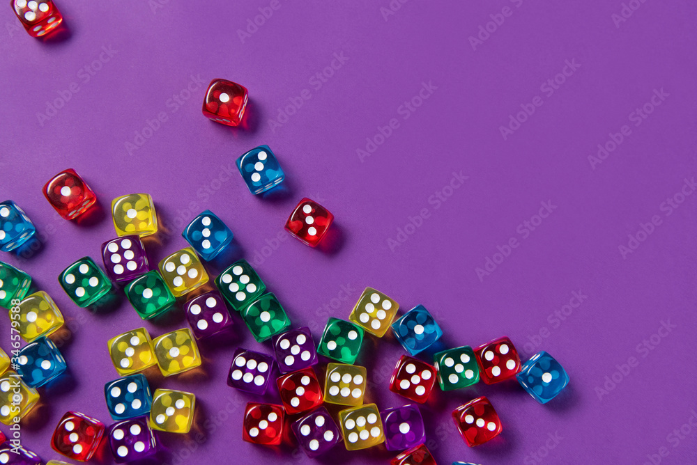 Bright and colorful dice set on violet background