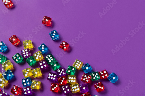 Bright and colorful dice set on violet background
