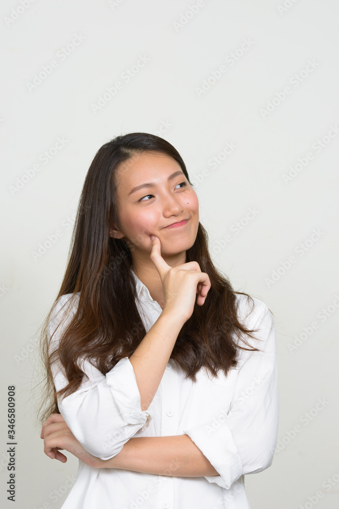 Portrait of young beautiful Asian businesswoman thinking Portrait of young beautiful Asian businesswoman thinking